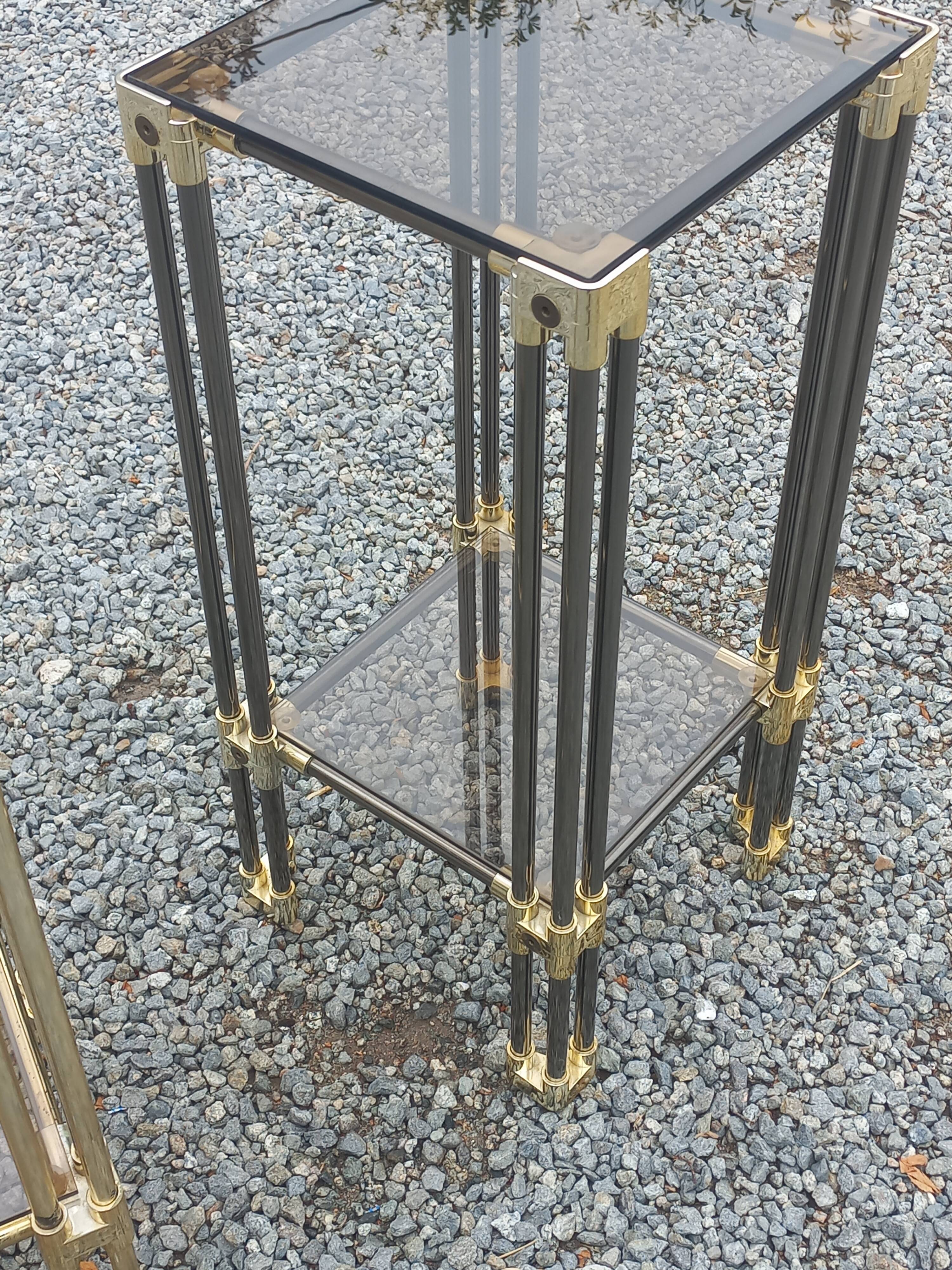 Pair of Hollywood Regency side tables in gold metal and smoked glass.