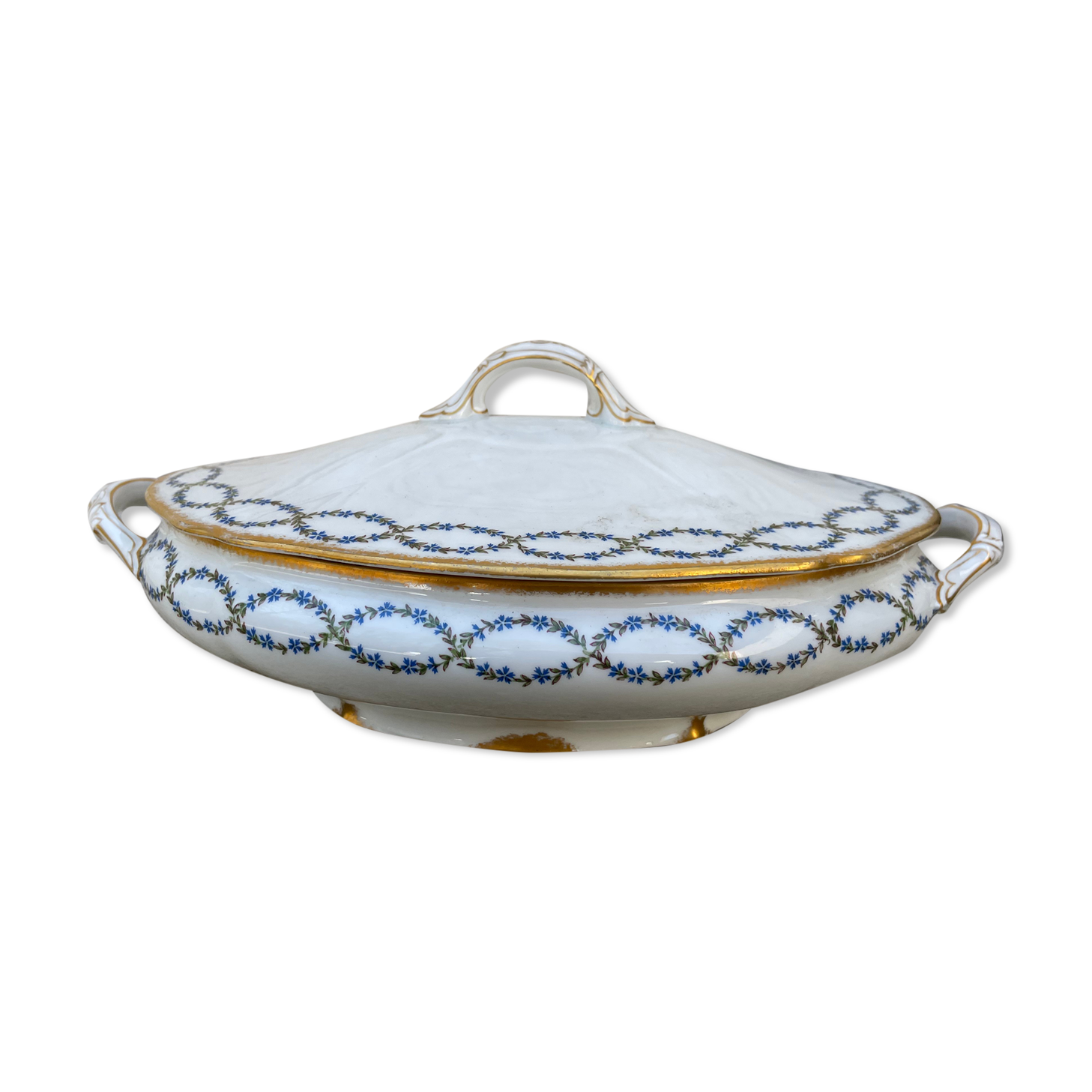 Old soup bowl with a golden border and decorated with small blue flowers
