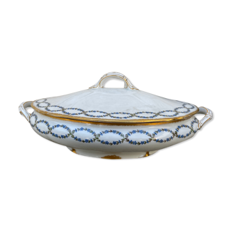 Old soup bowl with a golden border and decorated with small blue flowers