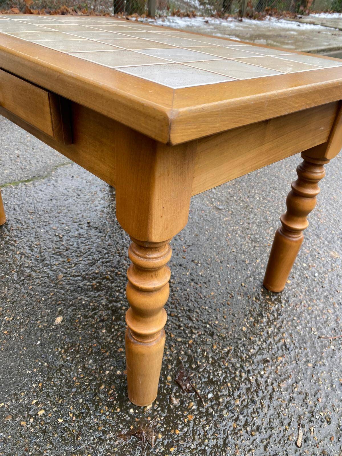 Light solid wood coffee table with tiles and a drawer.