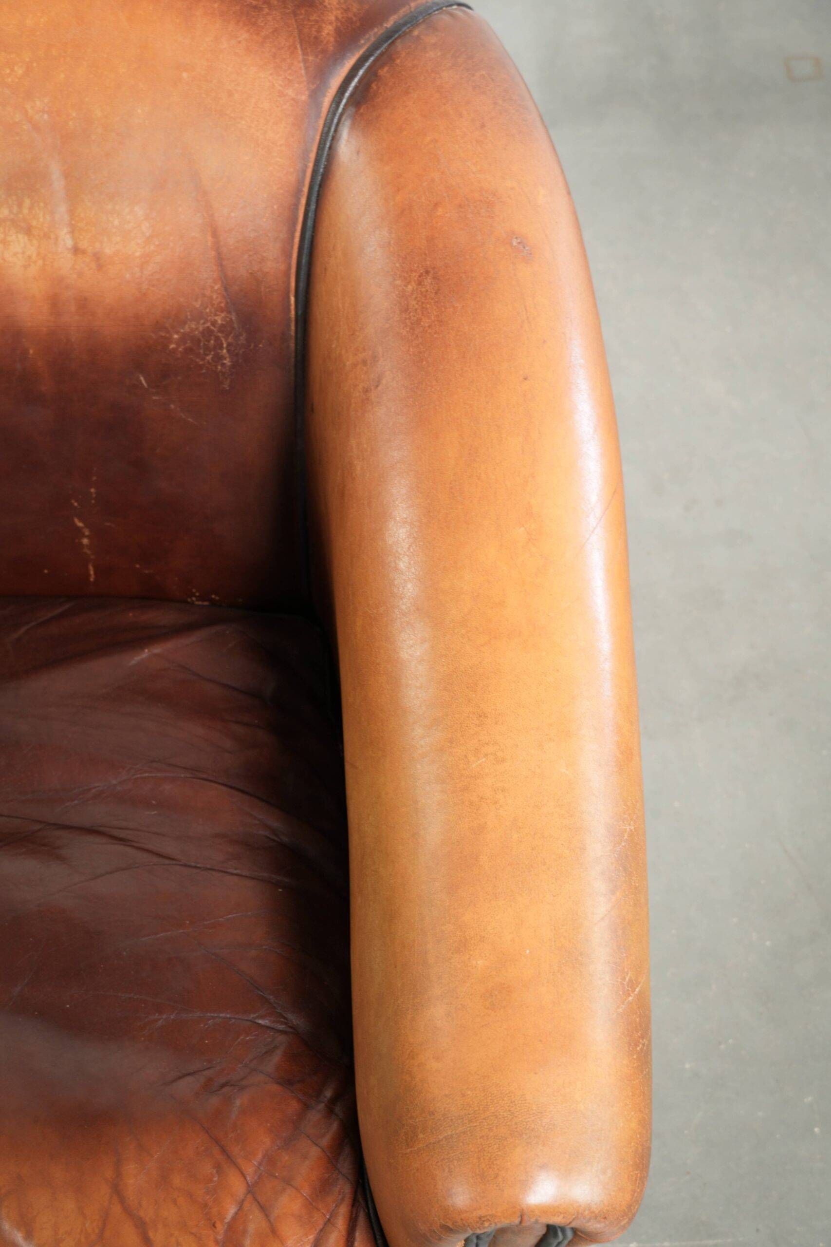Vintage sheepskin club armchair finished with black piping