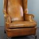 Old wingback armchair made of sheep leather in a correct condition