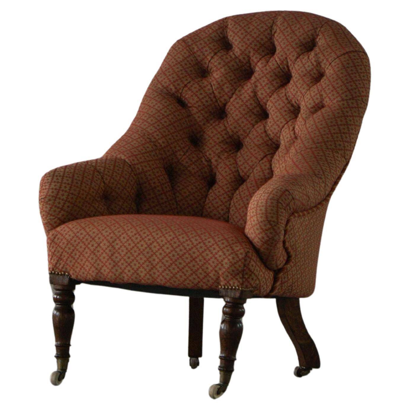 Victorian mahogany armchair, with wheels and coloured fabric, England, early 1900s.