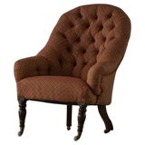 Victorian mahogany armchair, with wheels and coloured fabric, England, early 1900s.