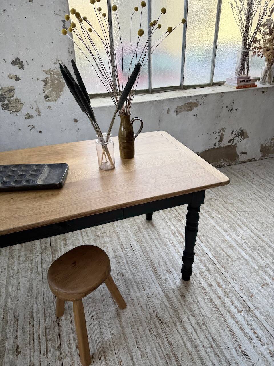 Oak farmhouse table with turned black legs.