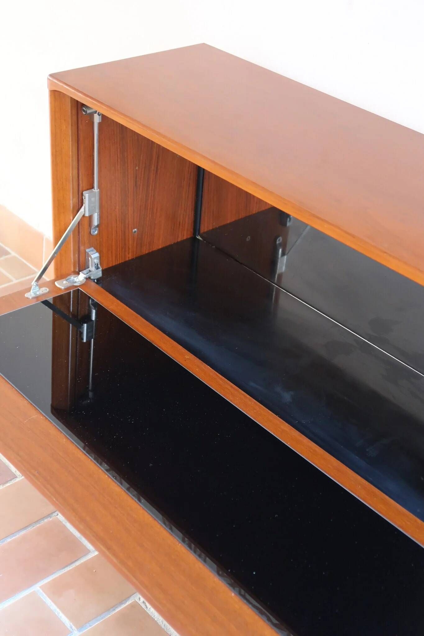 Vintage teak bar cabinet with black glass interior.
