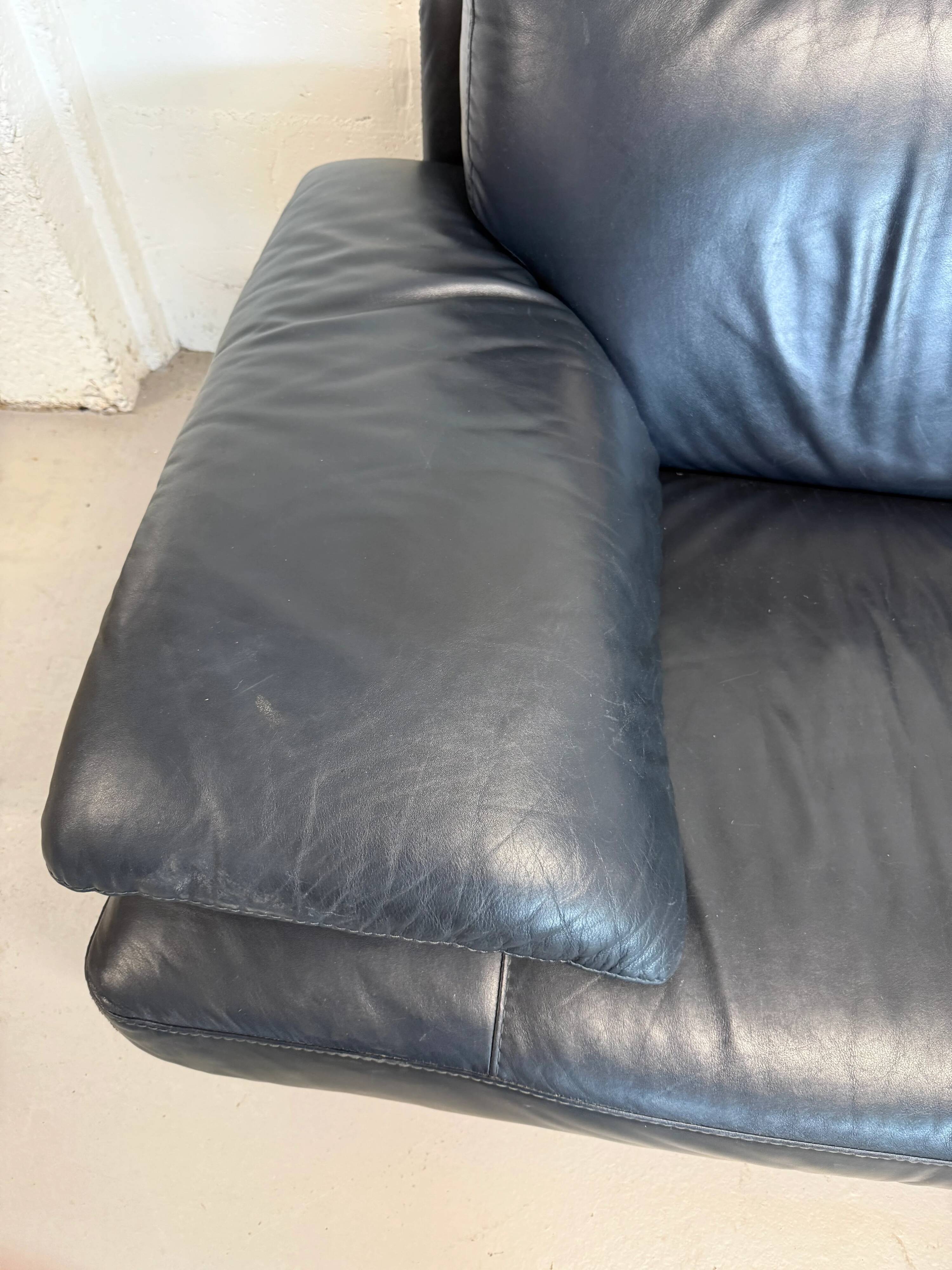 Two-seater Natuzzi sofa in navy blue leather.