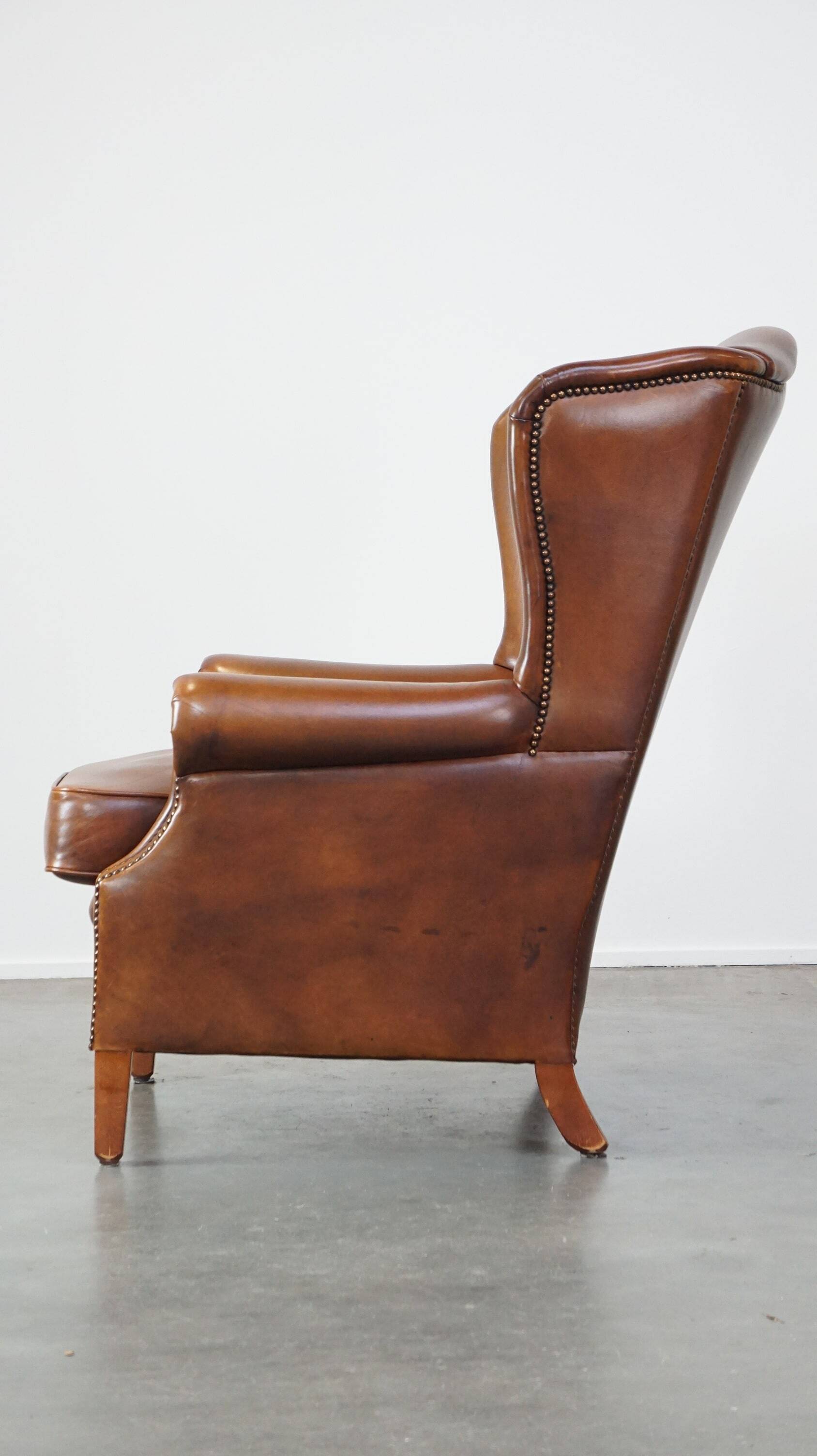Fauteuil à oreilles en cuir de vachette cognac