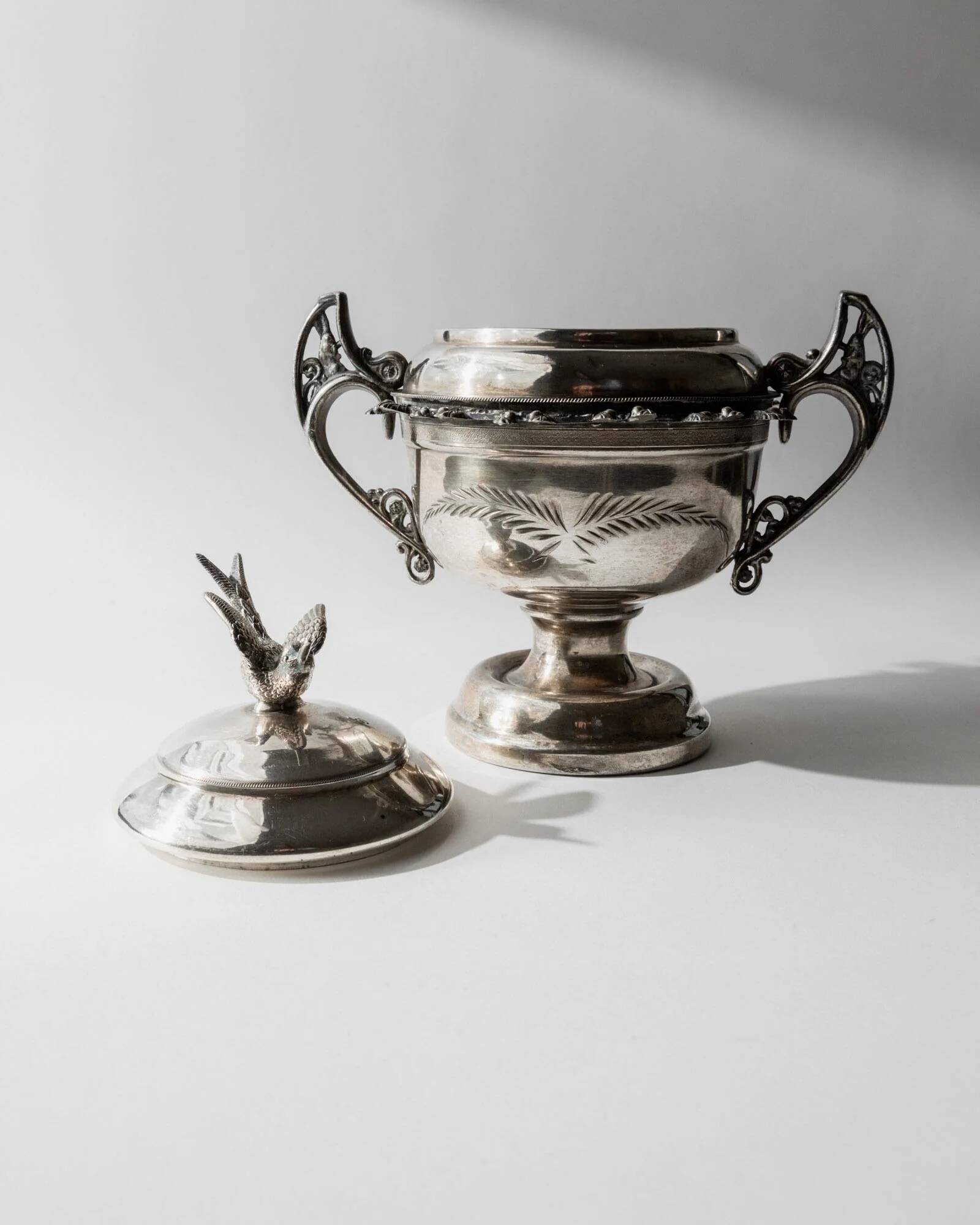 Vintage 1930s silver-plated footed bowl with lid by Warren Rogers New York, featuring a bird motif and ornate details.