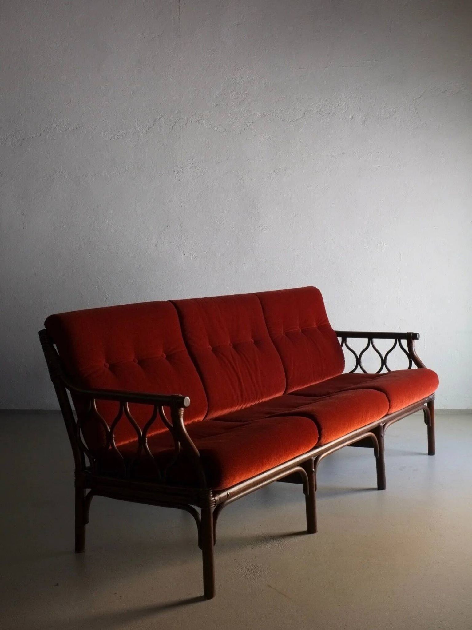 Dark rattan 3-seater sofa with red velour cushions | 1980s