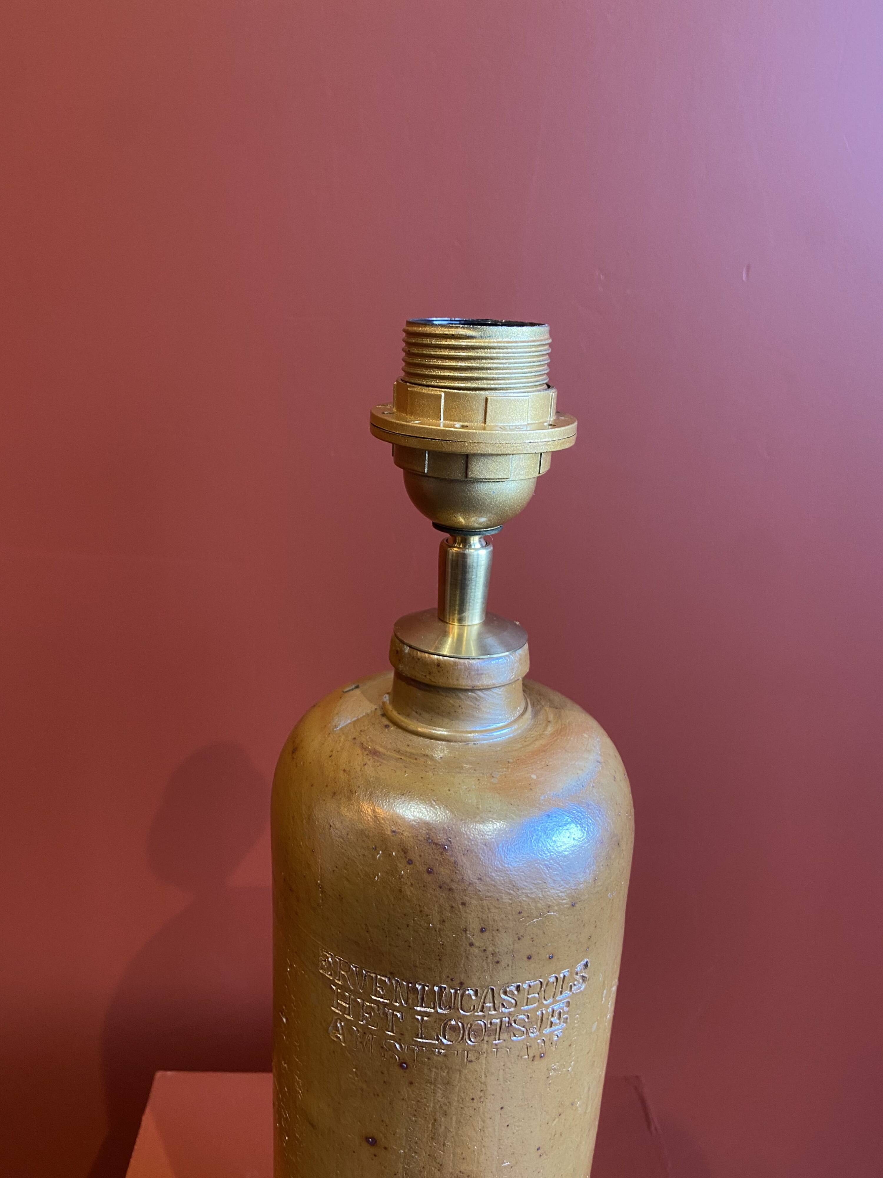 "Stoneware Bottle Lamp" with a multicoloured blue lampshade handwoven in India.