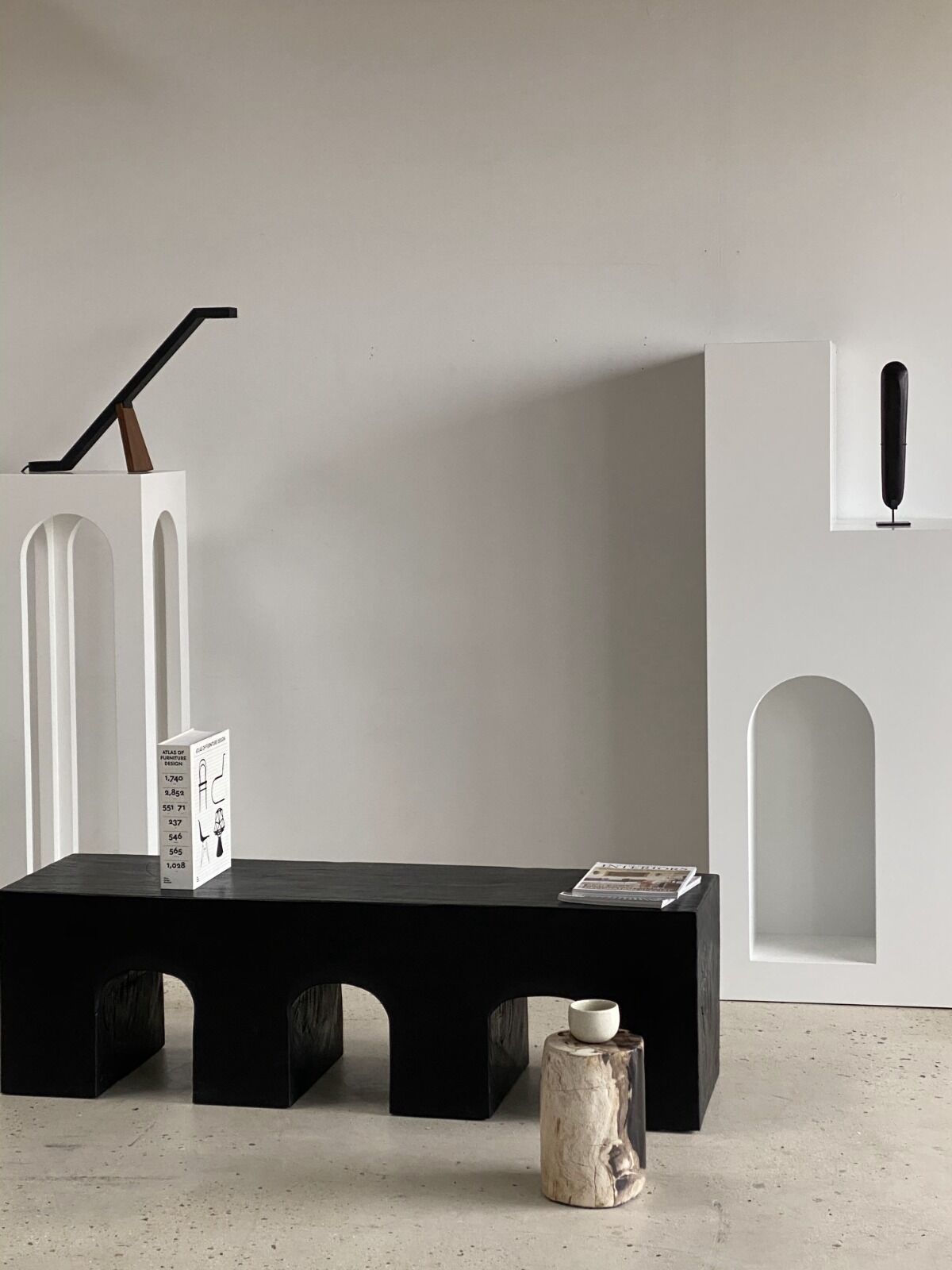 Black solid monoxyl wood bench carved into 3 arches