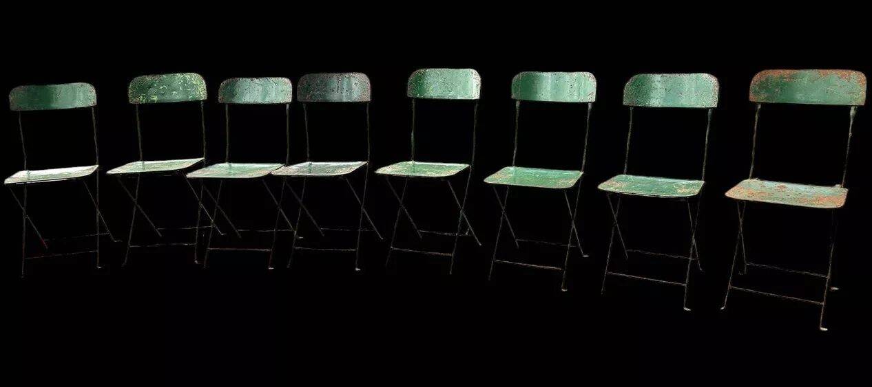 Set of 8 green painted metal industrial folding chairs.