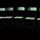 Set of 8 green painted metal industrial folding chairs.