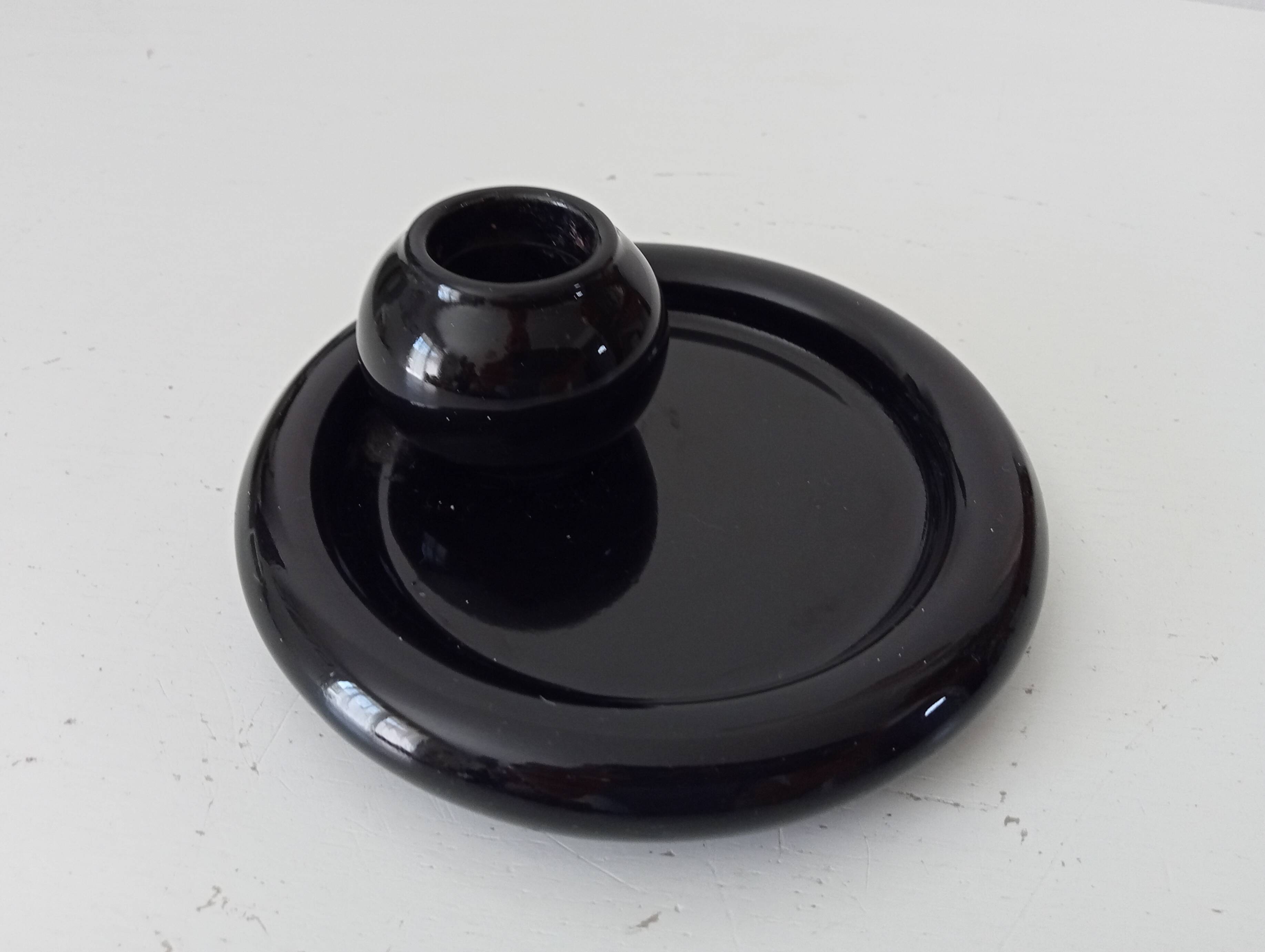 Vintage black ceramic candle holder on a bowl