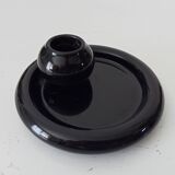 Vintage black ceramic candle holder on a bowl