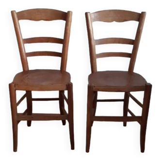 Pair of bistro chairs with pyrography designs.