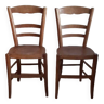 Pair of bistro chairs with pyrography designs.
