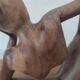 Wooden sculpted statuette of a woman in a pensive pose.