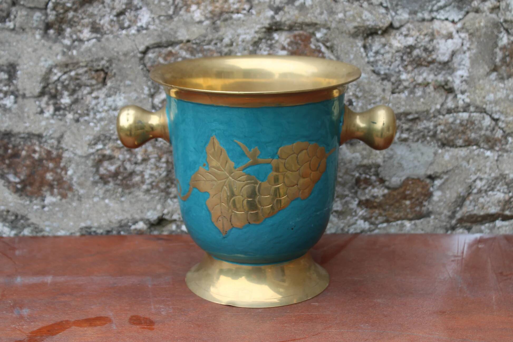 Vintage turquoise brass champagne bucket with grape decoration.