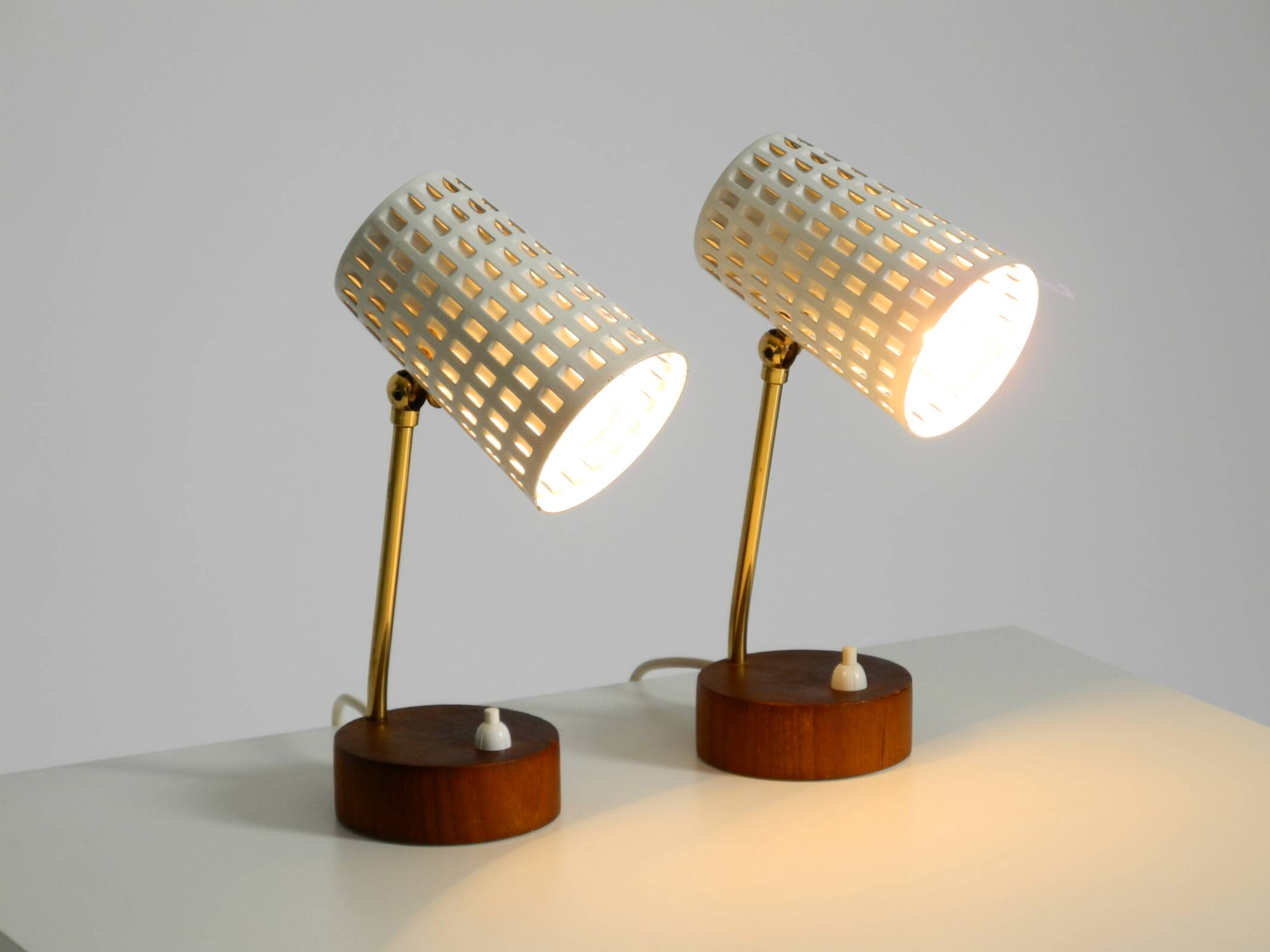 A pair of mid-century modern bedside lamps with perforated metal shades
