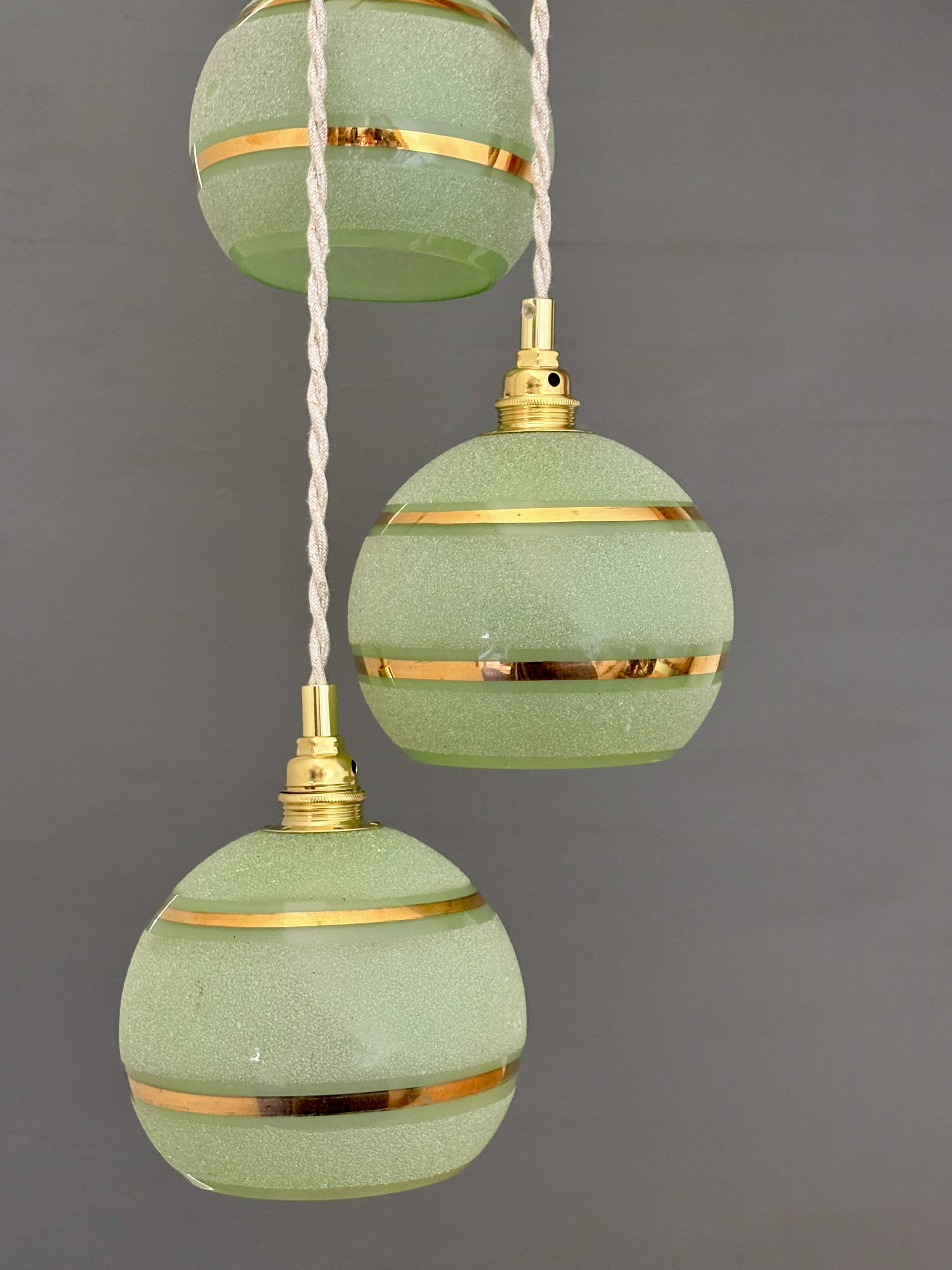 Suspension triple vintage glass globes in frosted green and gold.