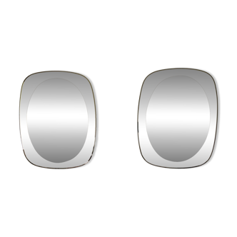 Pair of oval smoked glass mirrors, 1970s.