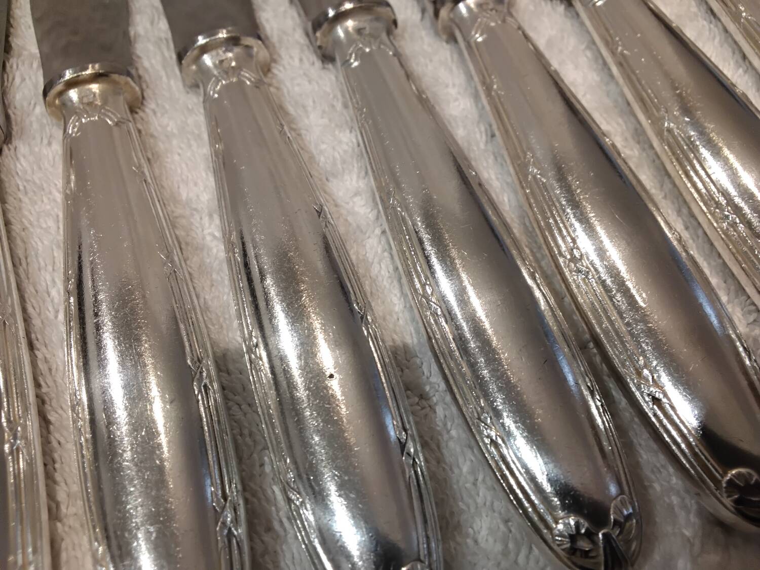 12 silver-plated table knives, Christofle goldsmith ribbons