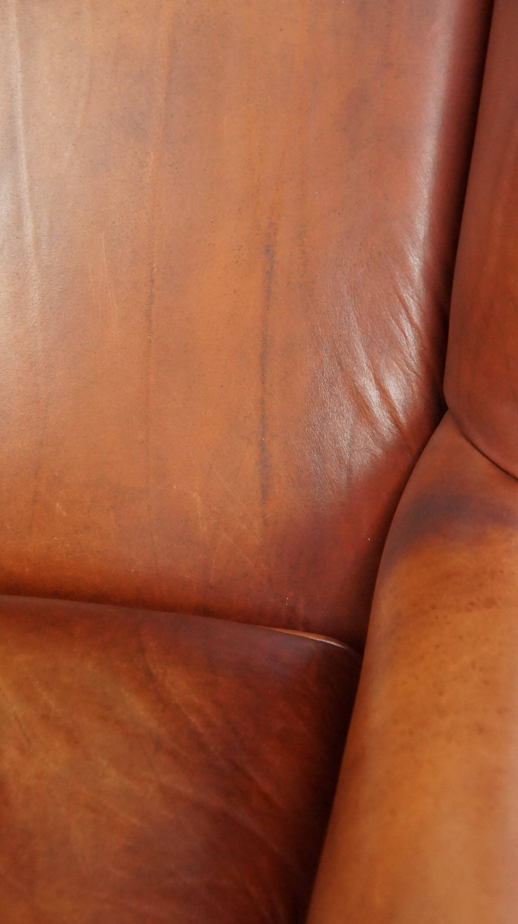 Fauteuil en cuir confortable et bien entretenu, fini avec des clous décoratifs de style anglais