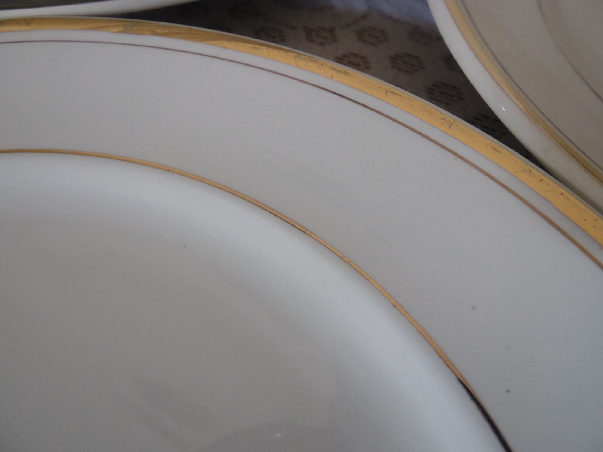 Set of 11 flat white earthenware plates with gold edging