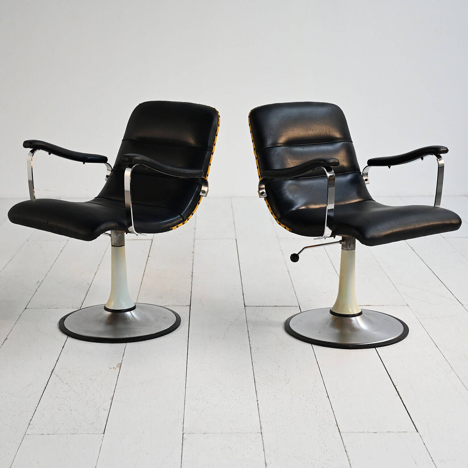 Pair of European 1970s swivel armchairs in faux leather and steel