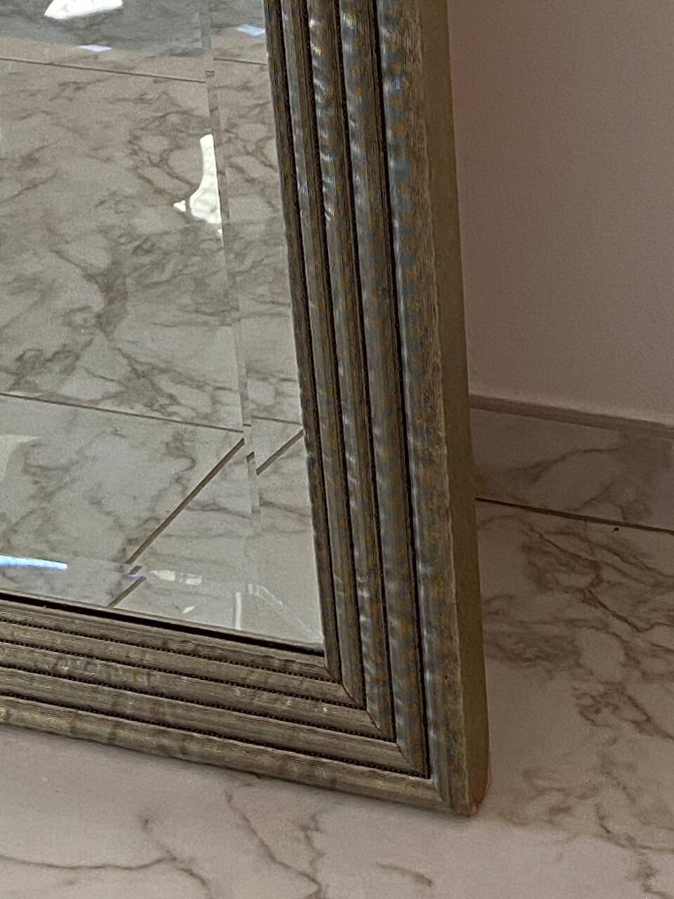 Textured embossed metal wall mirror with bevelled mirror.