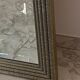 Textured embossed metal wall mirror with bevelled mirror.