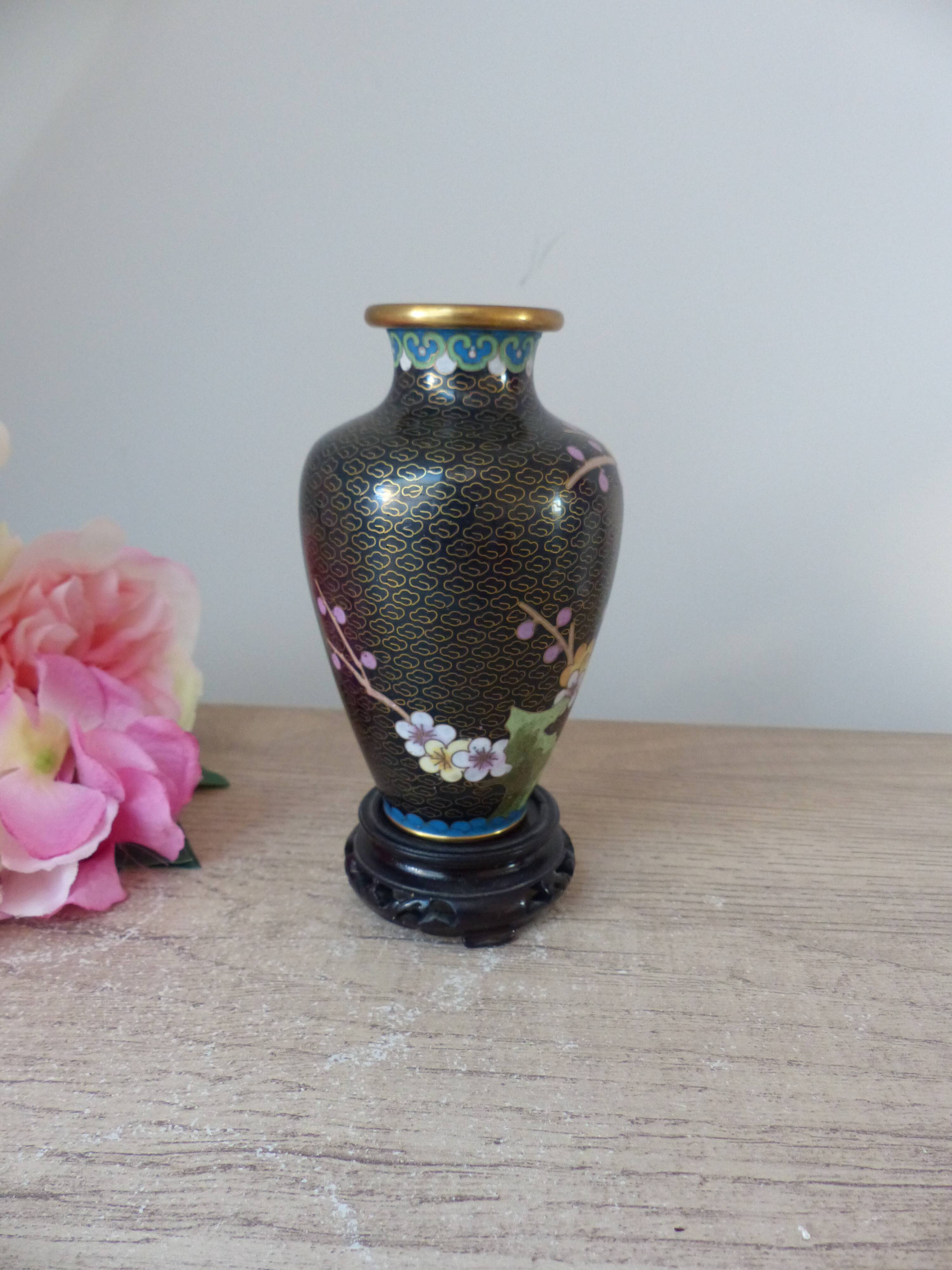 Small black cloisonné vase decorated with yellow and pink cherry blossoms, vase on wooden base