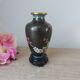 Small black cloisonné vase decorated with yellow and pink cherry blossoms, vase on wooden base