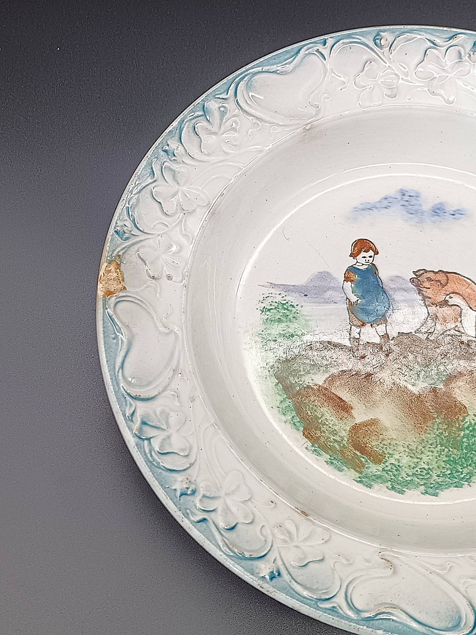 Large antique hollow dish from the 19th century, earthenware with pastoral decoration featuring a child, pig, and goose.