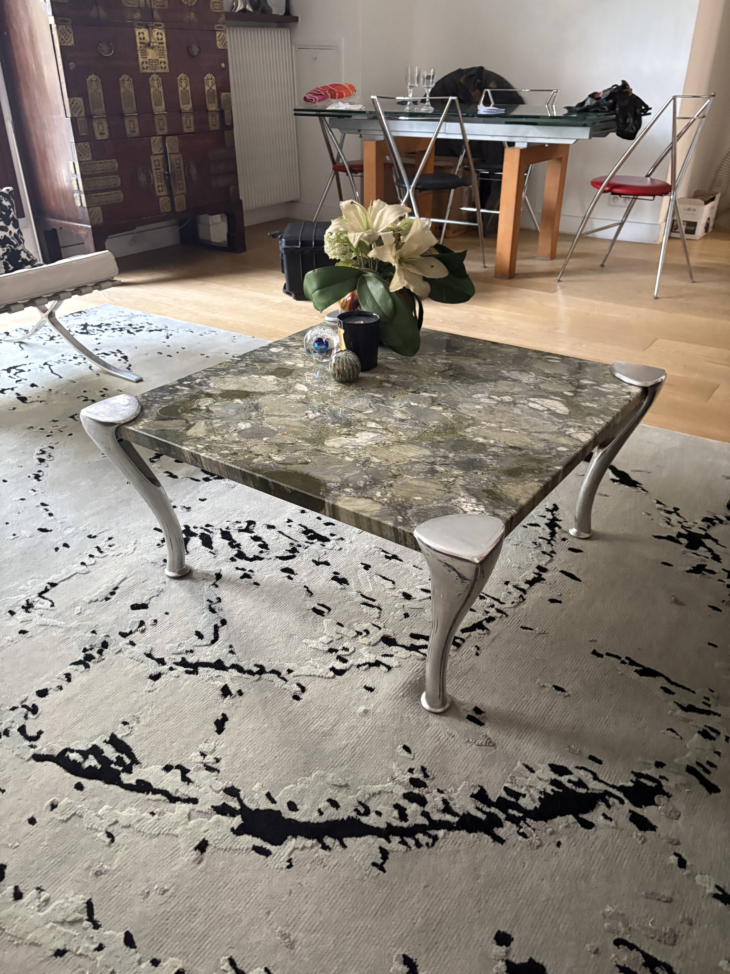 Contemporary coffee table with a marble top and steel base.