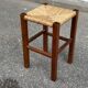 Low stool in brutalist style made of solid wood with straw, 1980.