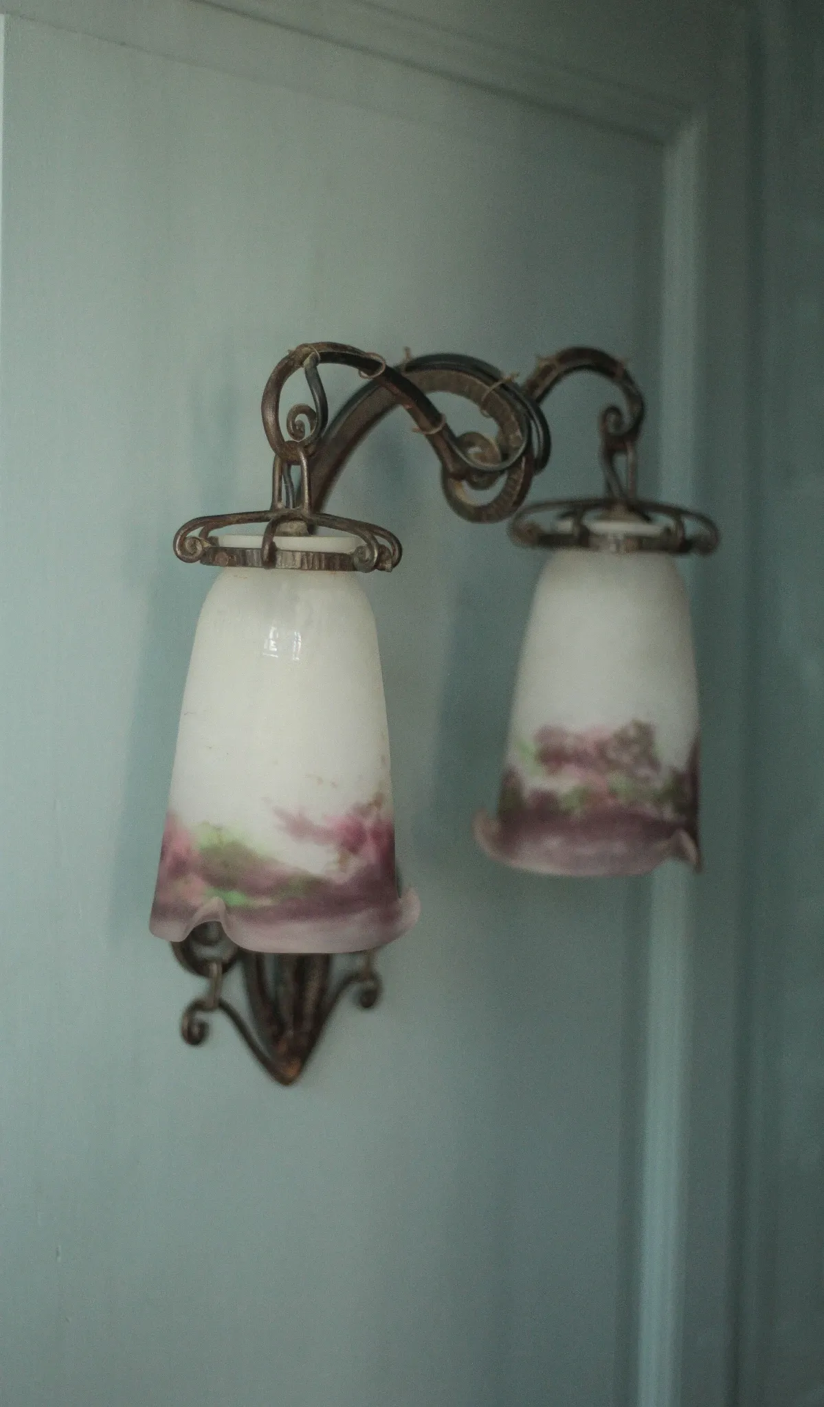 Wall lamp in wrought iron with a pink tulip glass globe by Muller glassworks.