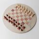 Vintage 1980s round chess set in marble, with a beige and pink marble board and wooden pieces.