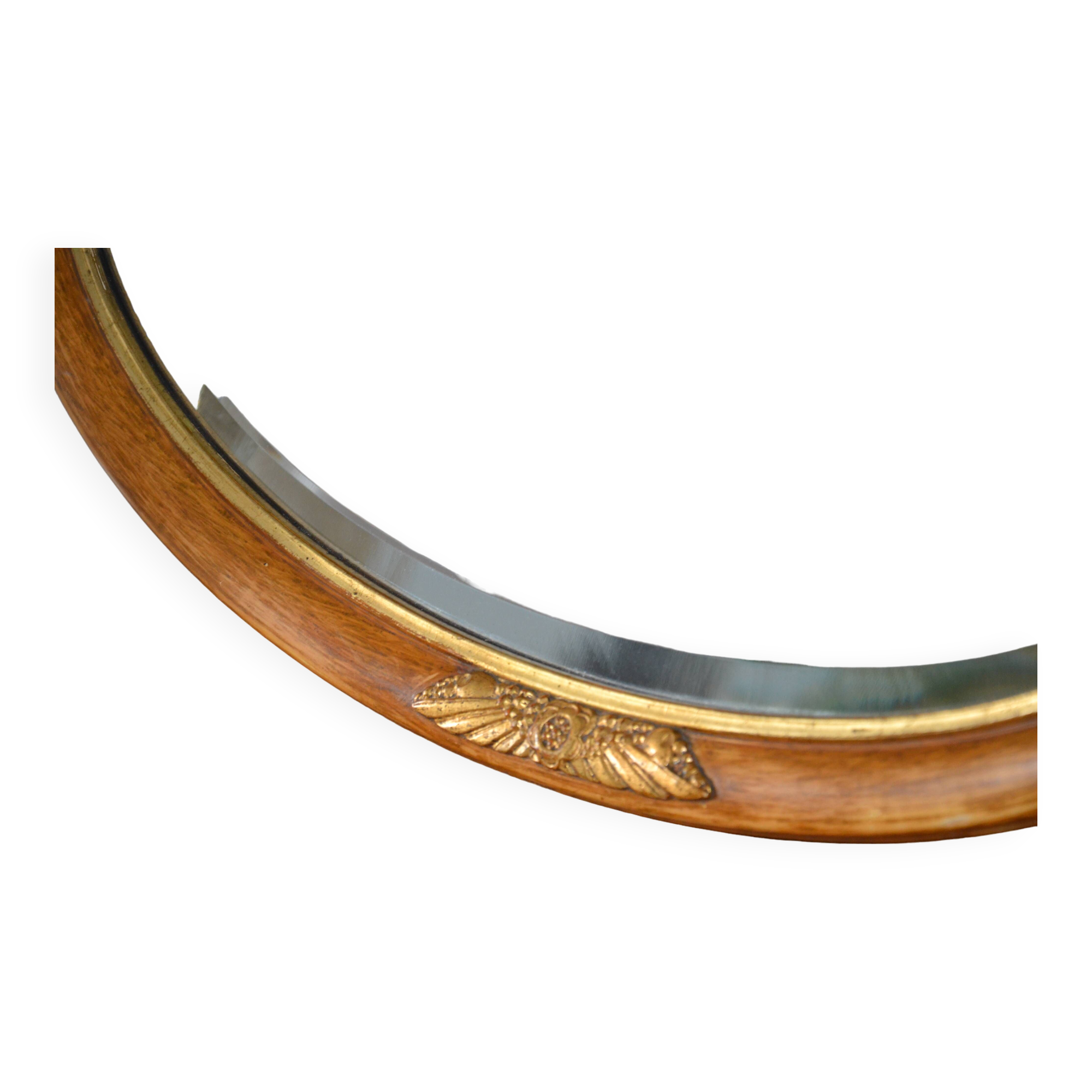 Old oval beveled wooden mirror, partly gilded and carved
