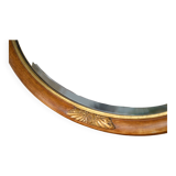 Old oval beveled wooden mirror, partly gilded and carved