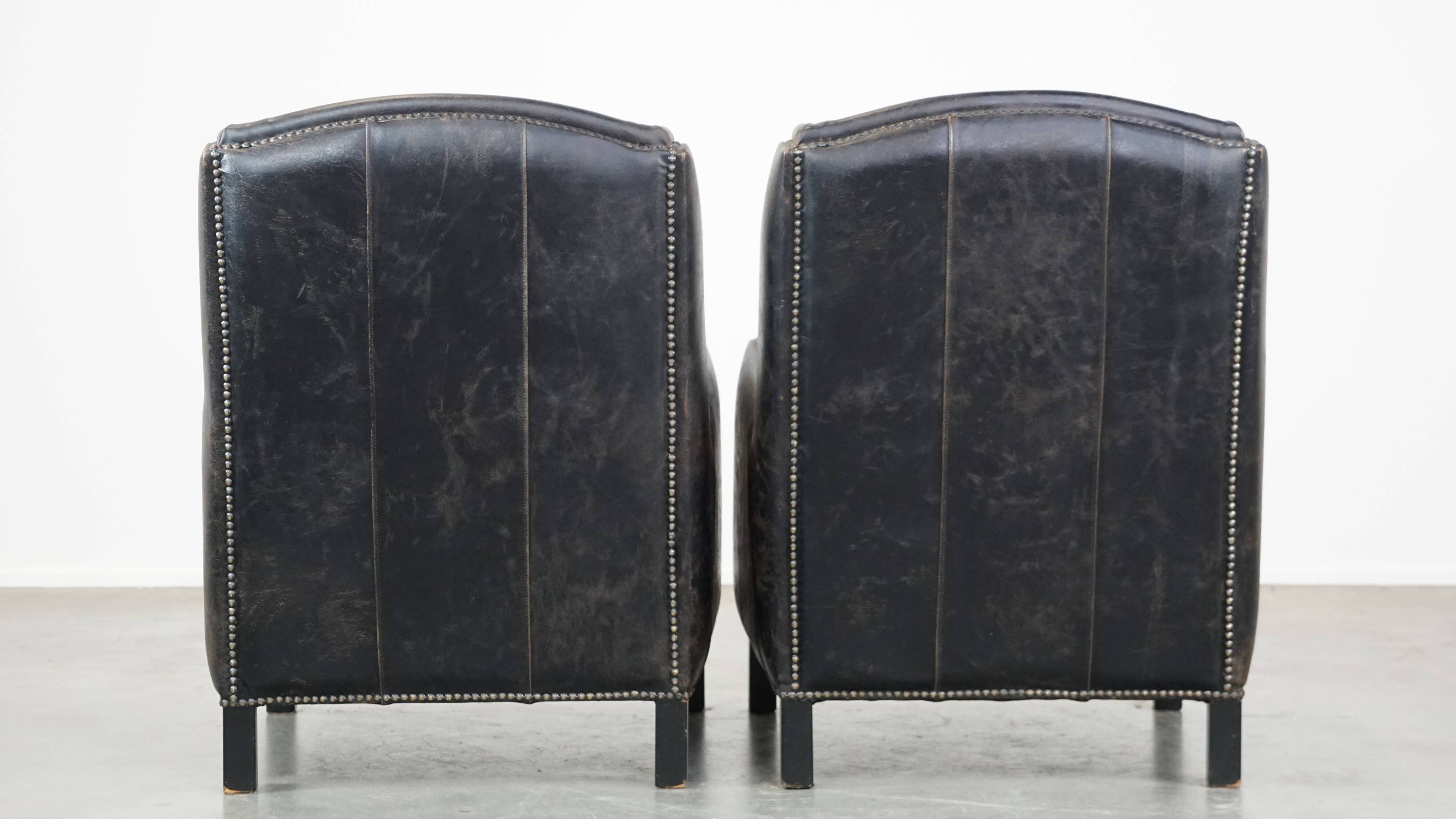 Set of 2 black cow leather armchairs finished with decorative nails, industrial style