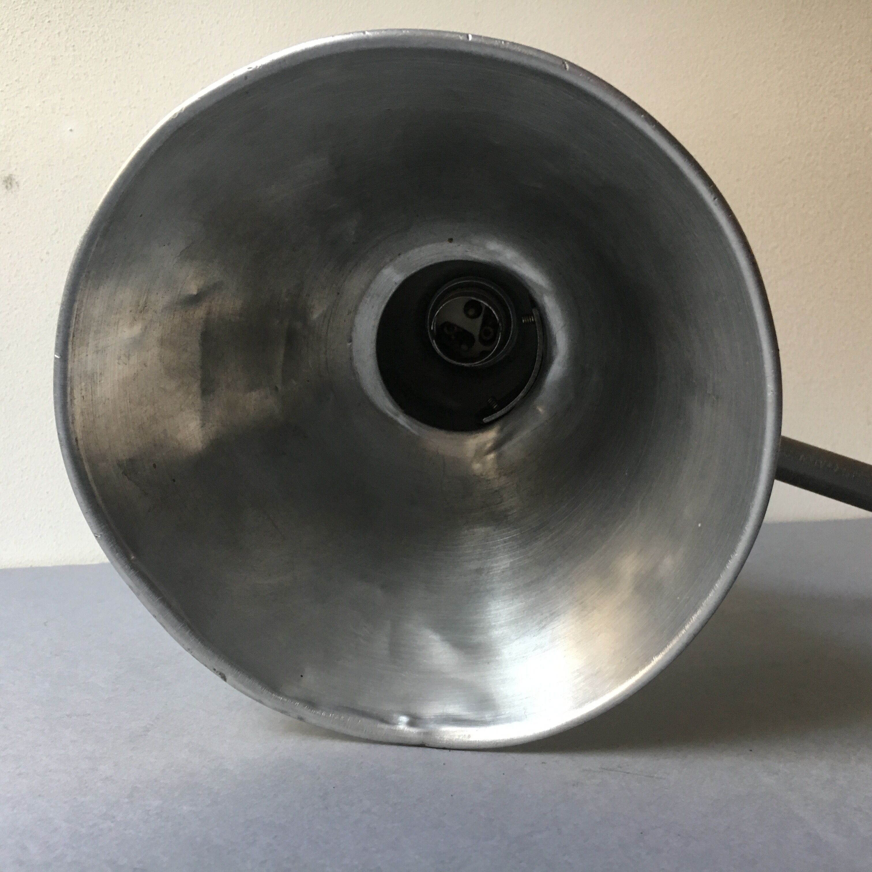 Old industrial lamp has vise 'mazda '.