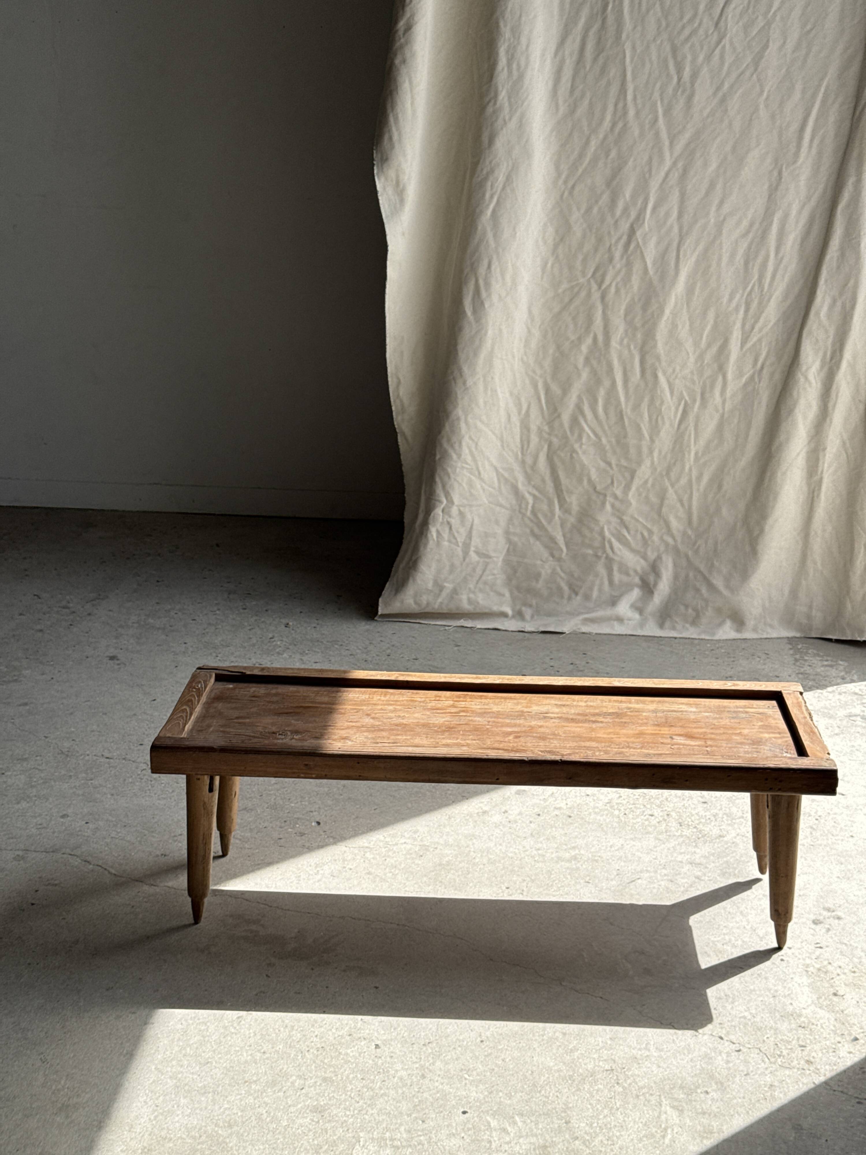Brown Indonesian teak coffee table, with a border and cylindrical legs H40 L103.