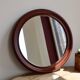 Round vintage mirror with mahogany wood effect frame.