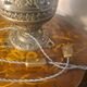 brass and bronze lamp with an antique base from 1900 and a glass paste shade
