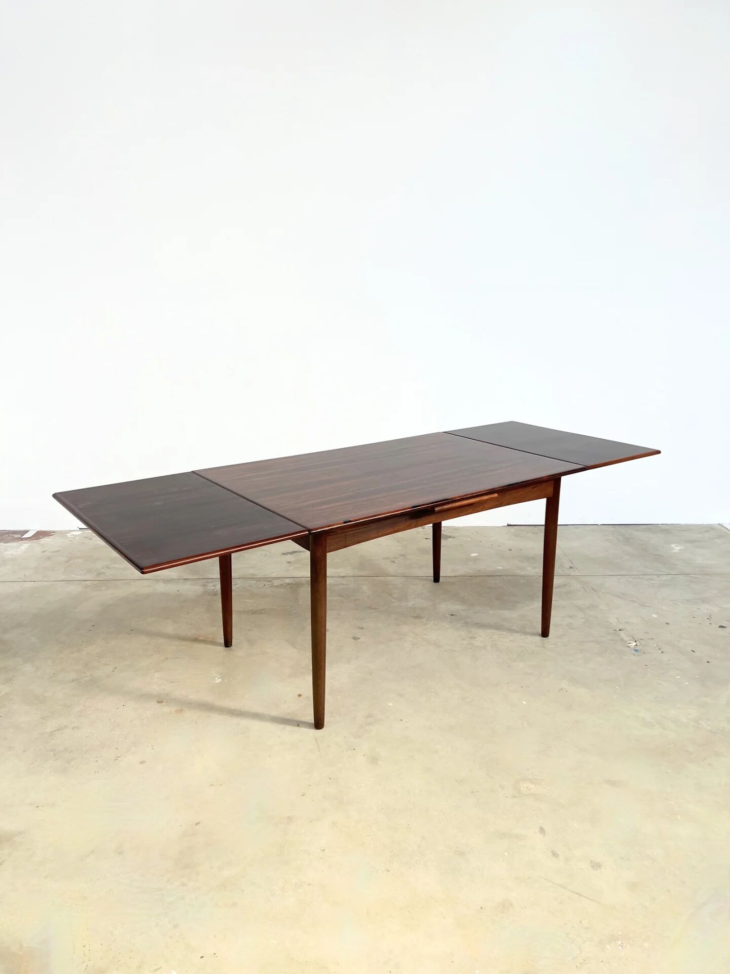 Rosewood dining table with integrated extensions — Denmark, 1960s