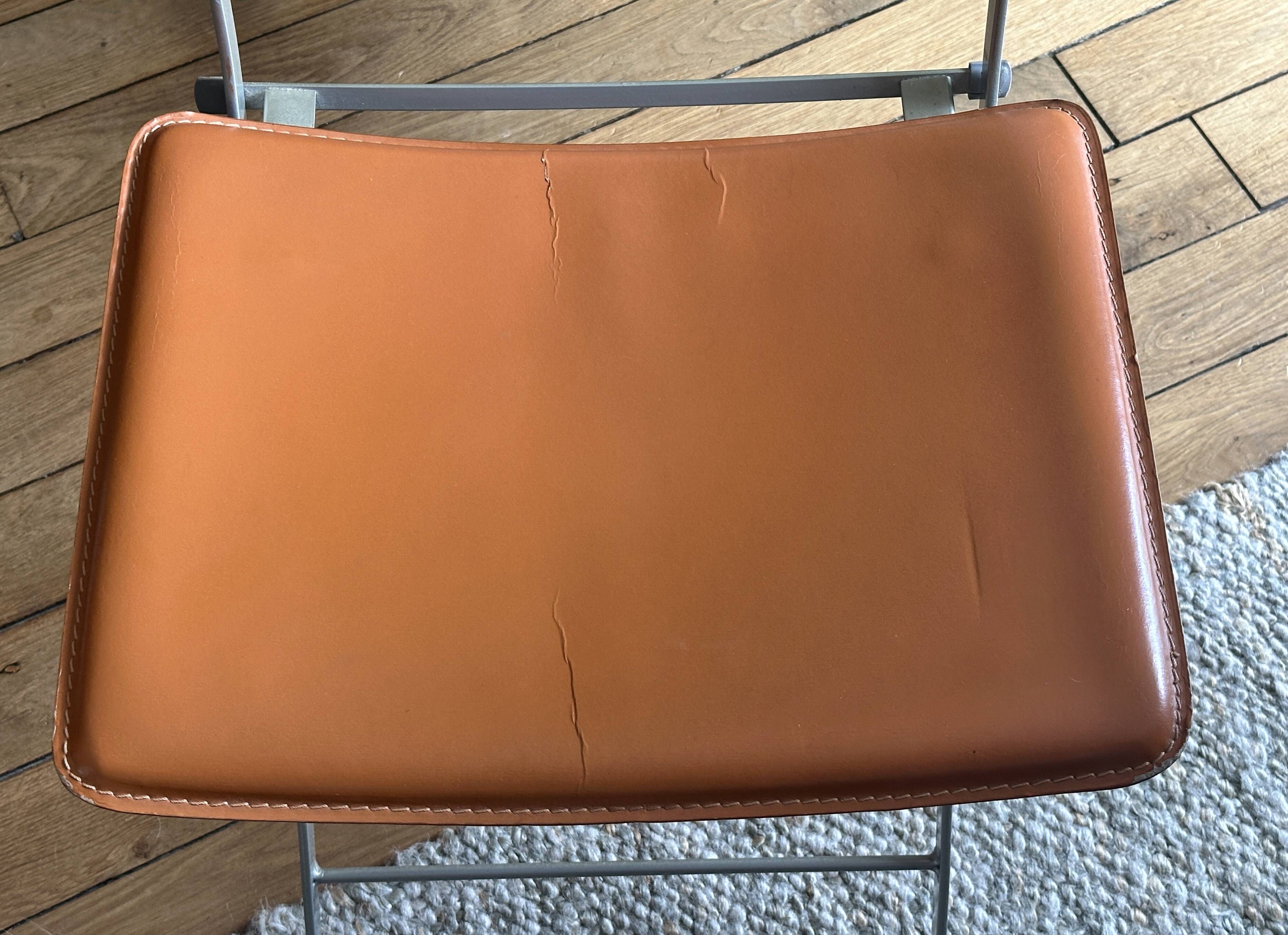 4 folding Sintesi chairs for DWR Lina in metal and vintage camel leather.