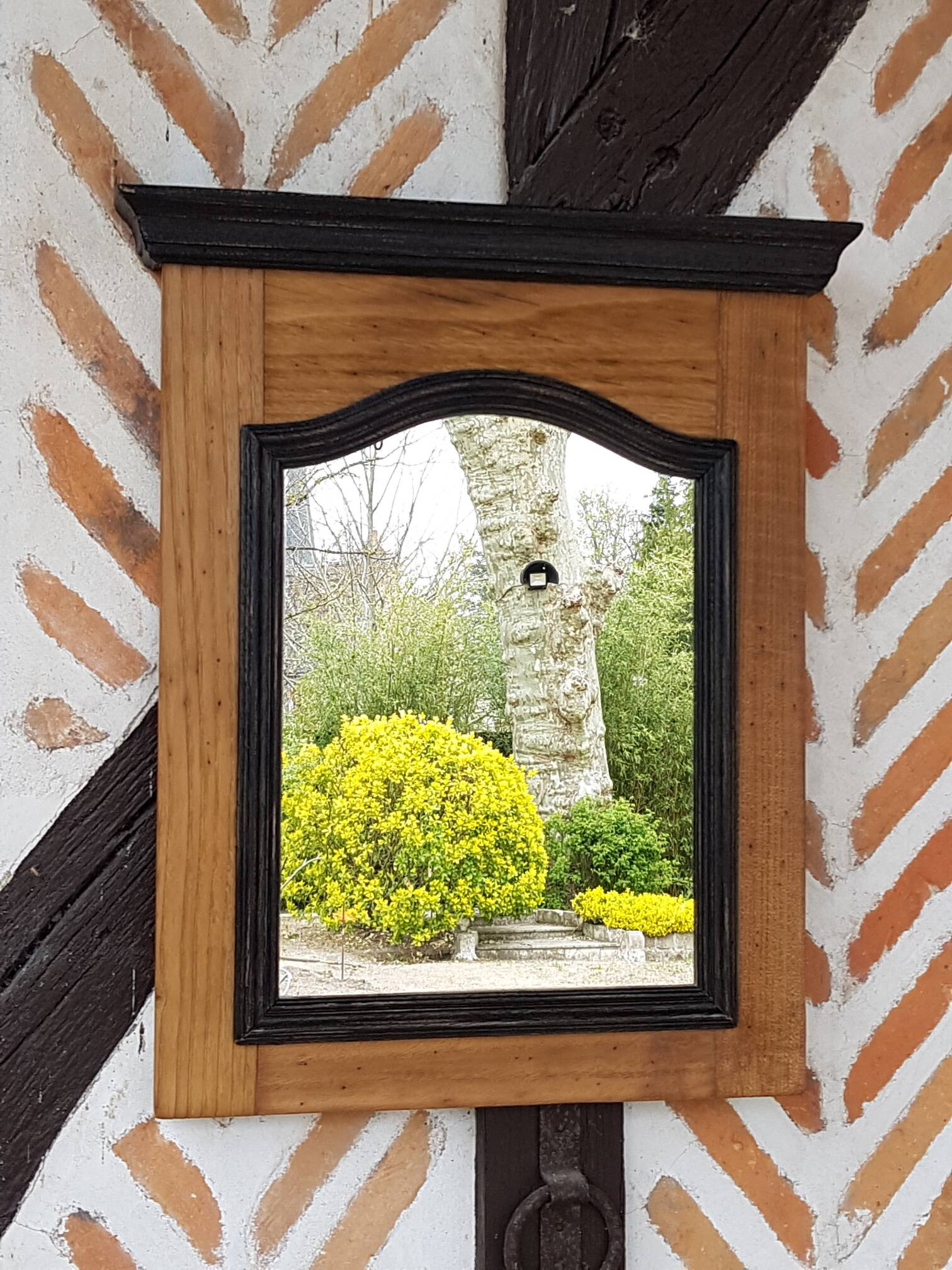 Black mirror and raw natural wood